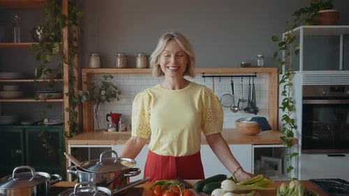 mujer mayor cocinando y divirtiéndose en casa.
