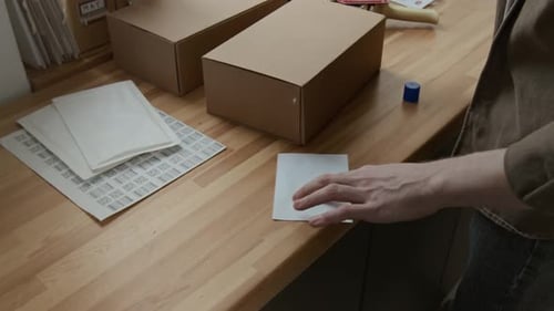 Man Preparing Shipping Box with Label at Desk