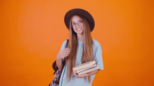 Smiling Woman Student Holding Books Wearing Hat