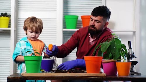 Father Ans Child Son Growing Plant in Pot
