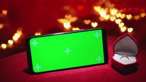 A Romantic Valentines Day Setting Featuring a Beautiful Ring Alongside a Green Screen Phone Ideal