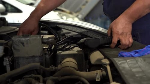 Mechanic Repairing Car Engine in Automotive Shop