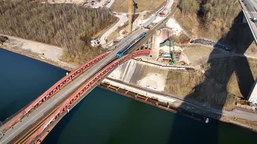 Aerial view of train crossing historic red iron bridge over canal. Aerial view of bridge replacement