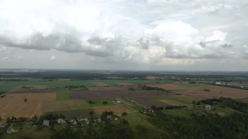Drone flying over the country fields near small town and reveals beautiful country fields view with