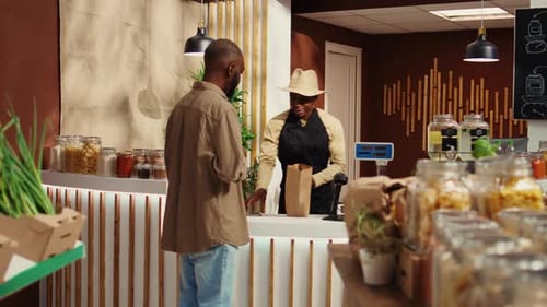 Male Client Paying for Nonpolluting Pantry Supplies at Market