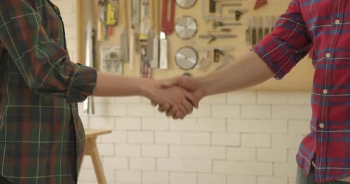 2 Shot of Hand shake woodworker dealer young man and woman carpenter building project