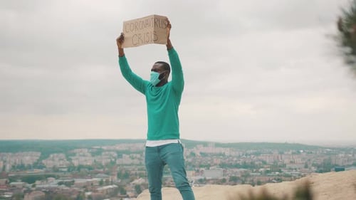 Man Holds Coronavirus Crisis Sign on Hill