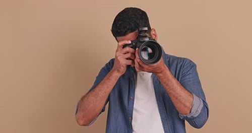 Young Man with DSLR Camera Posing in Studio