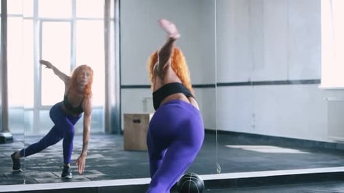 Woman Doing Lunges with Medicine Ball in Gym