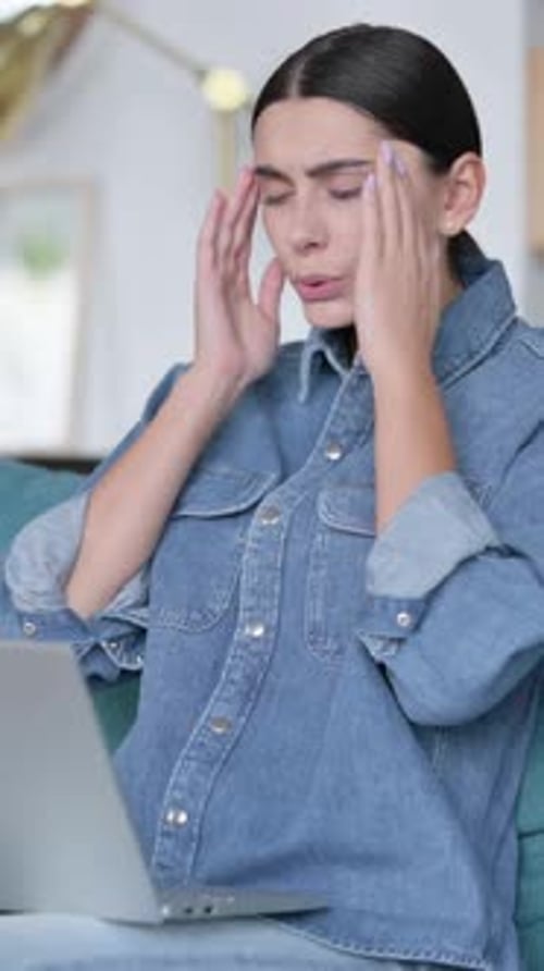 Woman Works on Laptop, Gets Headache, Touches Temples