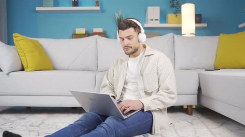 Young man thinking about a sad event listening to sad music.