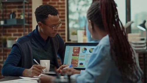 Business Colleagues Discussing Charts and Graphs in Office