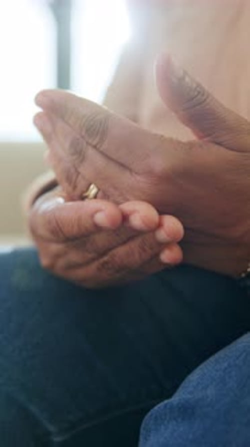 Mature woman rubbing her hands indoors