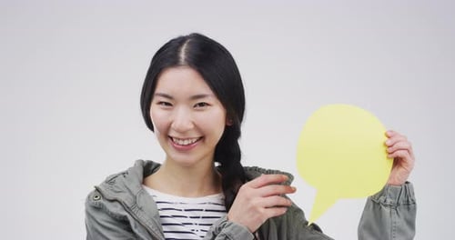 Smiling Woman Presenting a Yellow Speech Bubble