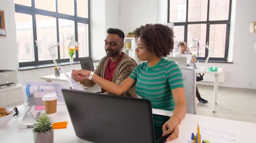 Business, Technology and Creative People Concept - Designers Discussing Project and Working