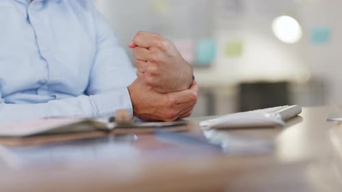 Man Massages Wrist and Types on Keyboard