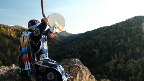 Shaman Playing Ritual Drum on Mountain Top