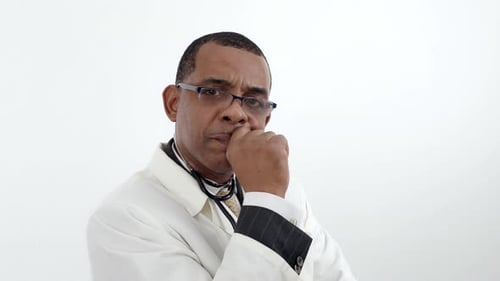 Jamaican African-American man doctor in white lab coat in glasses, turning head looking at the camer