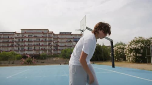 Young Boy Athlete Dribbles Energetically On Basketball Court