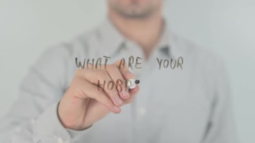 Man Writes "What Are Your Hobbies" on Glass