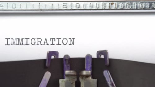 Immigration word closeup being typing and centered on a sheet of paper on old vintage typewriter