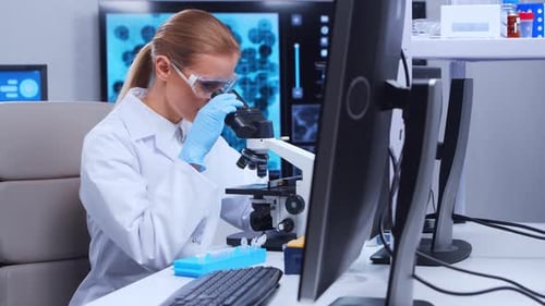 Scientist Works with Microscope in Modern Lab