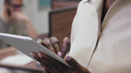 Hands of Black Woman Scrolling on Tablet in Coworking