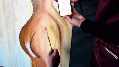 Beautiful woman painting with watercolors at an art gallery workshop