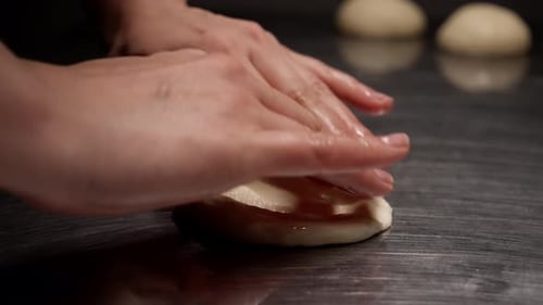 Hands Flattening Dough Circle for Baking Preparation