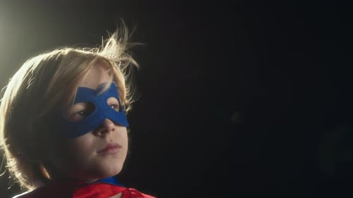 Young Boy in Superhero Costume Looking Up
