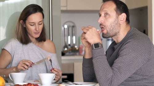 Couple eating breakfast together in their kitchen