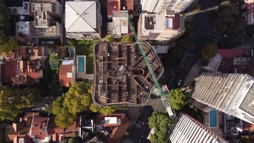 Una toma aérea fija de arriba hacia abajo que gira sobre el edificio en sentido antihorario. Construcción múltiple