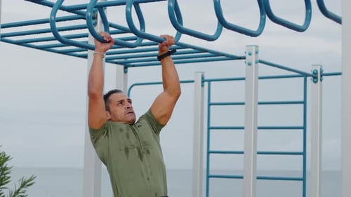 Man Doing Pull Ups Across Monkey Bar
