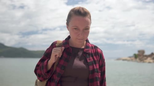 Smiling Woman with Backpack on Tropical Coastline