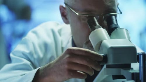 Scientist Using Microscope in Brightly Lit Laboratory