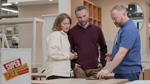 Shop Assistant Helping Couple with Choosing Table