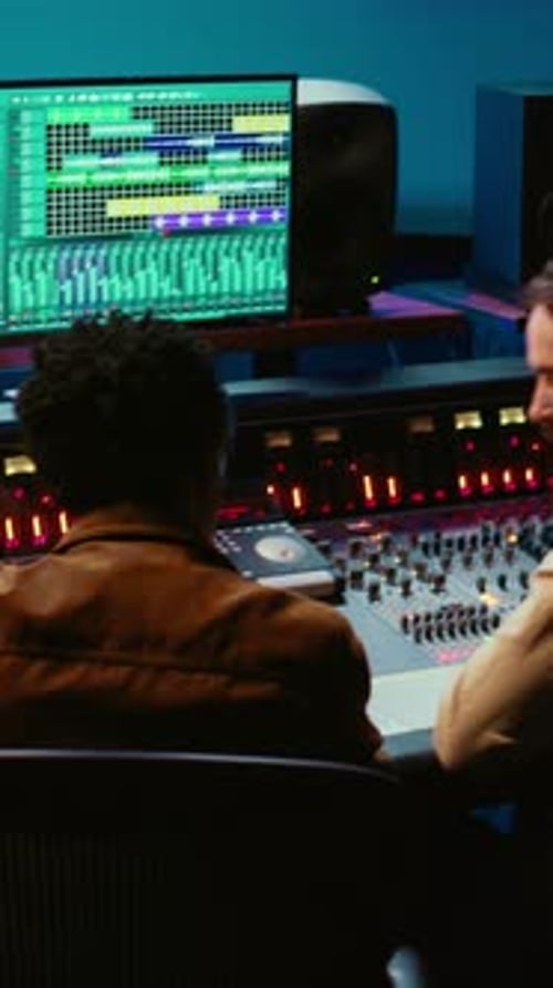 Music Producers Collaborate in Recording Studio at Night