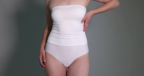 Woman in underwear on grey background, closeup