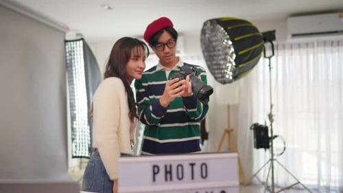 Asian beautiful woman model and cameraman working in photography studio.