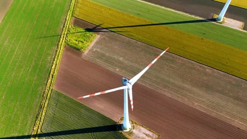 Long blades of wind turbine rotate in the wind. Top view on the windmill producing green energy.