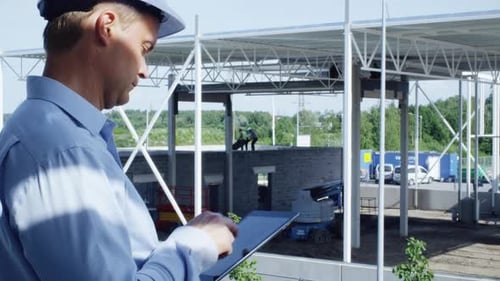 Engenheiro em Hard Hat com Tablet PC em construção