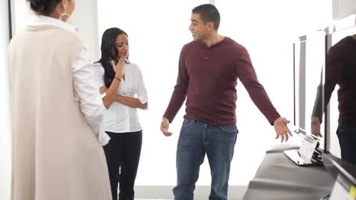 Couple shopping for televisions from salesperson at store