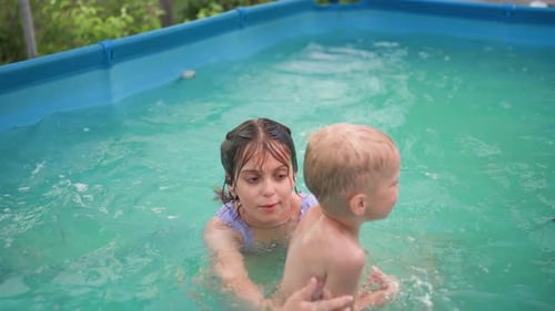 Children Splashing and Playing in a Backyard Pool