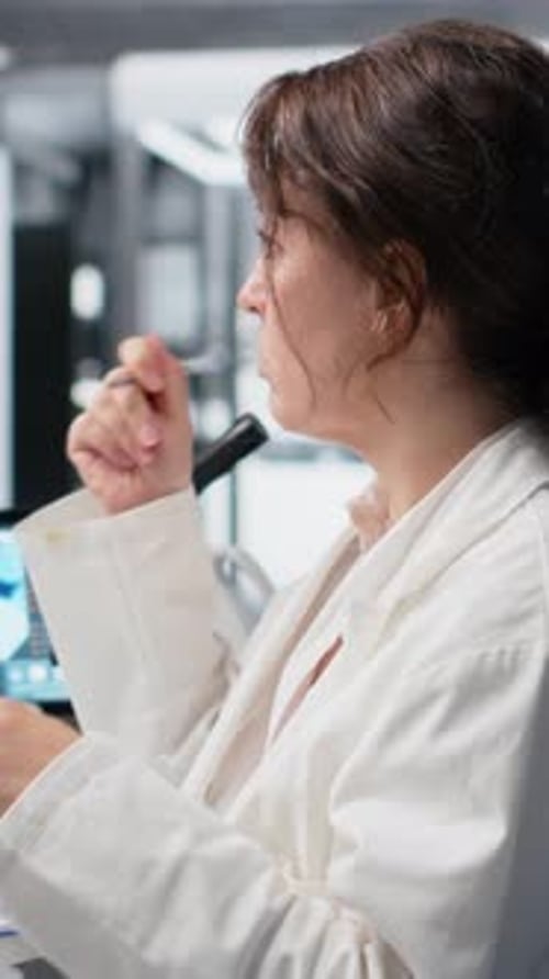 Woman Scientist Working with Microscope and Taking Notes