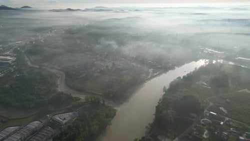 A river is shown in the distance with a foggy sky