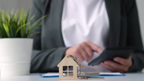 Businesswoman in Bank Office Calculating Mortgage or Home Loan