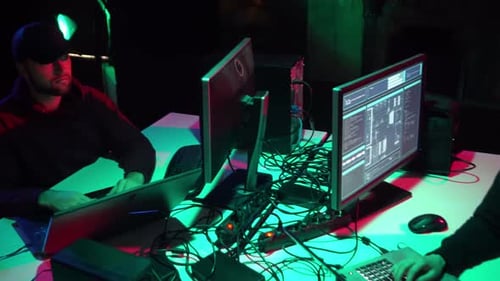 Two Young Adults Coding in Dramatic Lighting