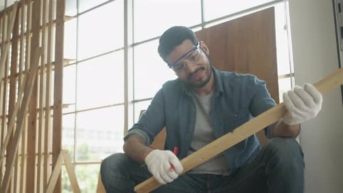 Craftsman Marks Wood for Carpentry Project