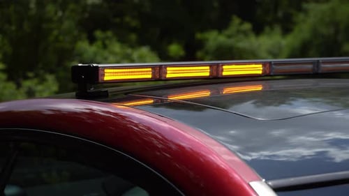 Flashing yellow emergency light on car roof. Flashing amber warning lightbar at the security car
