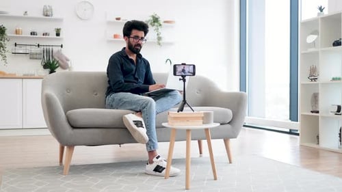 Young Man Recording Vlog at Home on Laptop